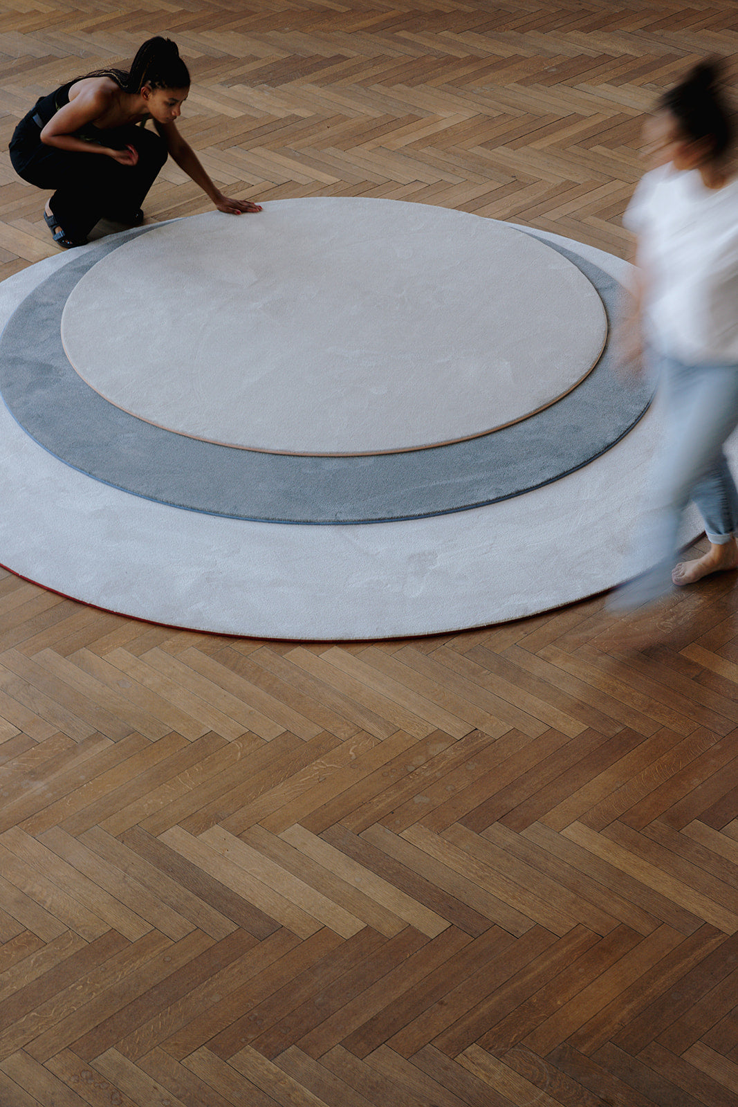 Ronde duurzame tapijtcollectie Maison Forton op parket vloer.
