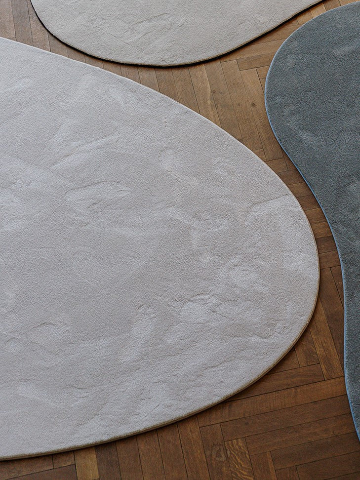 Detail biophilic shapes vloerkleden op parket vloer.