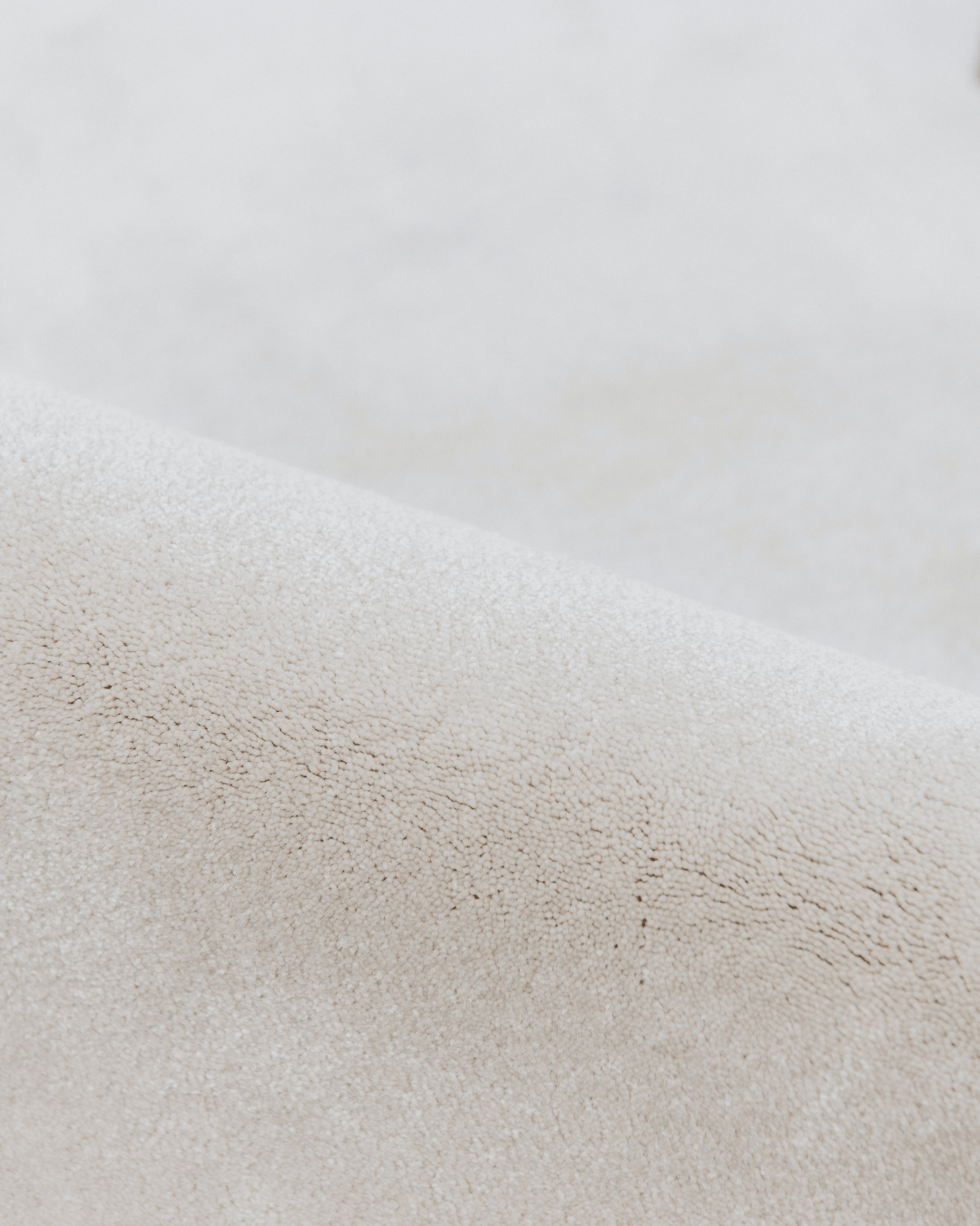 Detail zacht materiaal duurzaam tapijt met opverend garen in een beige tint, beach kleur.