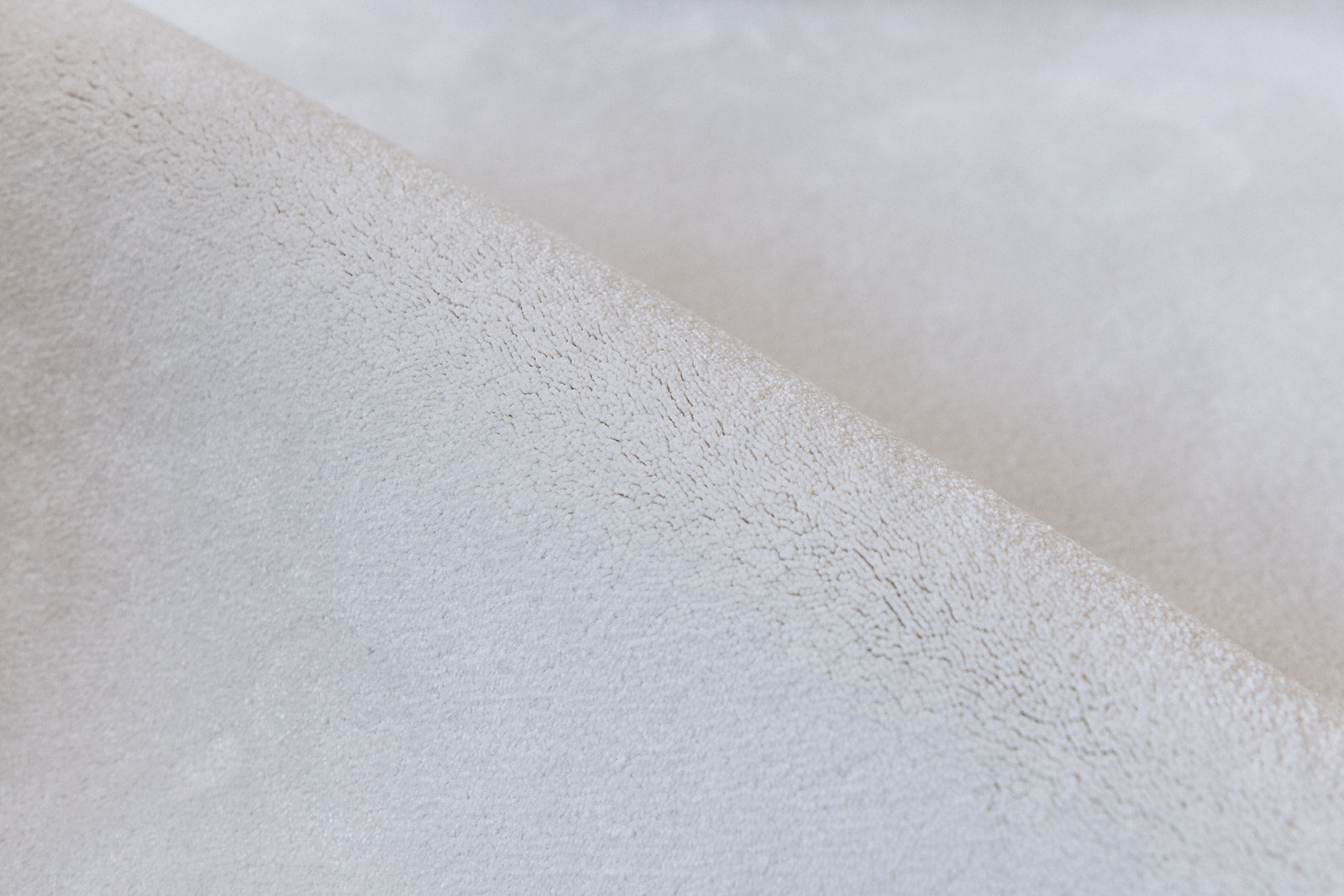 Detail zacht materiaal duurzaam tapijt in een witte tint, tender kleur.