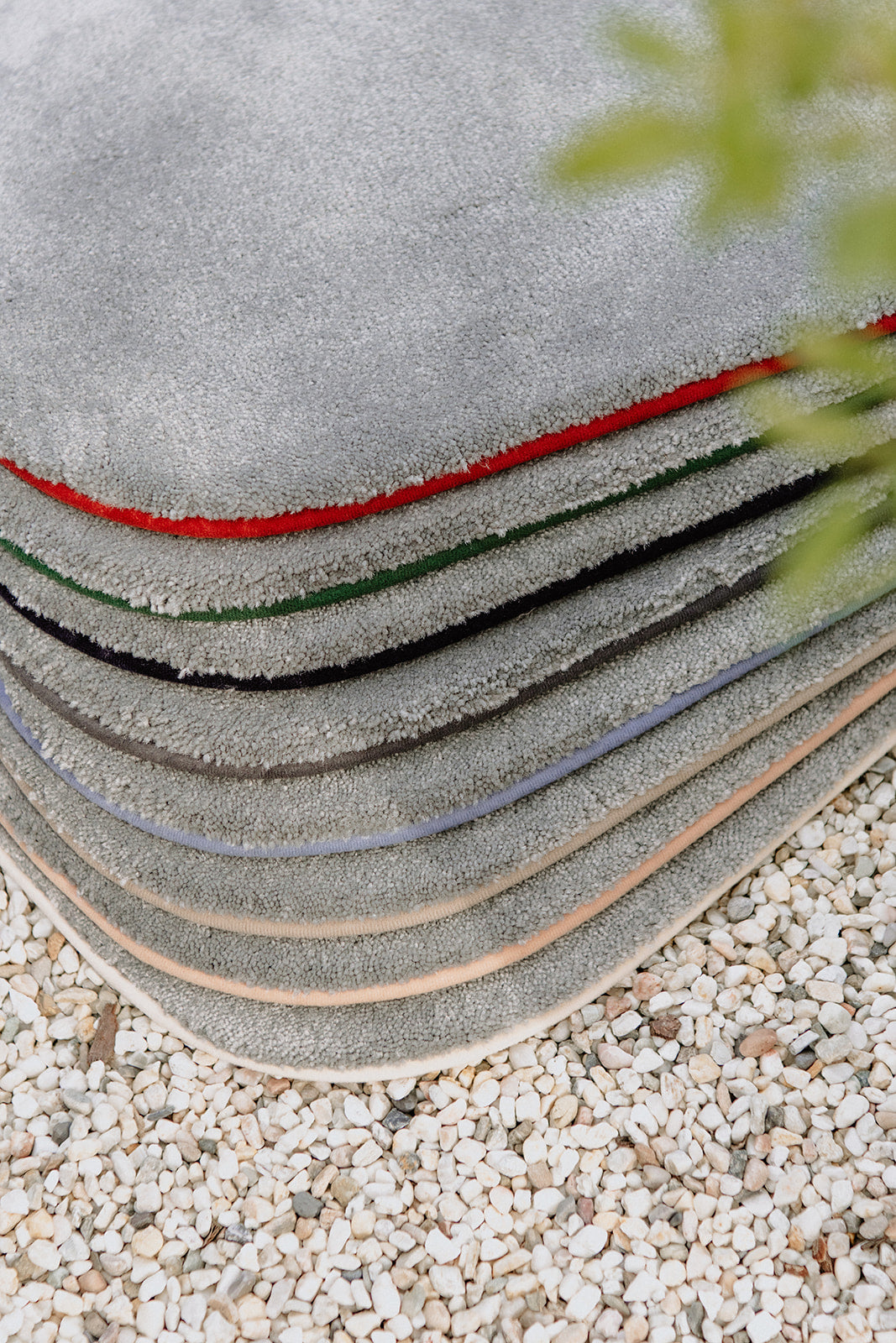 Gestapelde gerecyclede tapijtstalen in grijze stone kleur met verschillende te personaliseren kleurranden.
