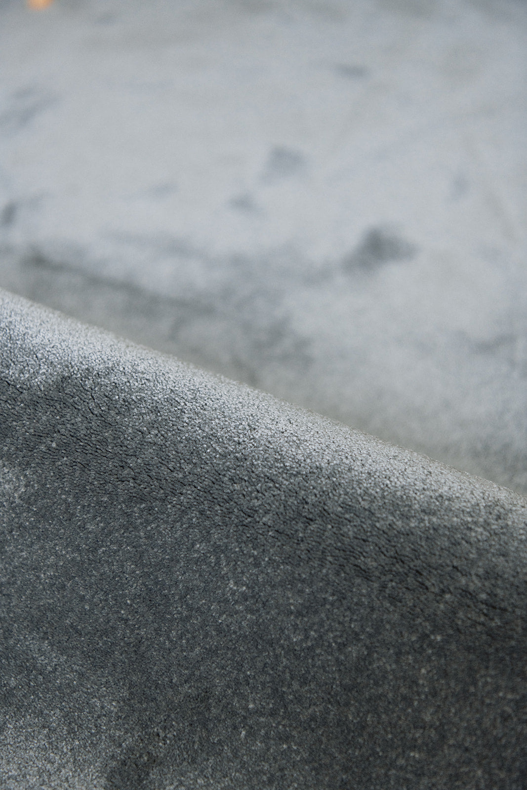 Detail zacht materiaal duurzaam tapijt in een grijze tint, stone kleur.