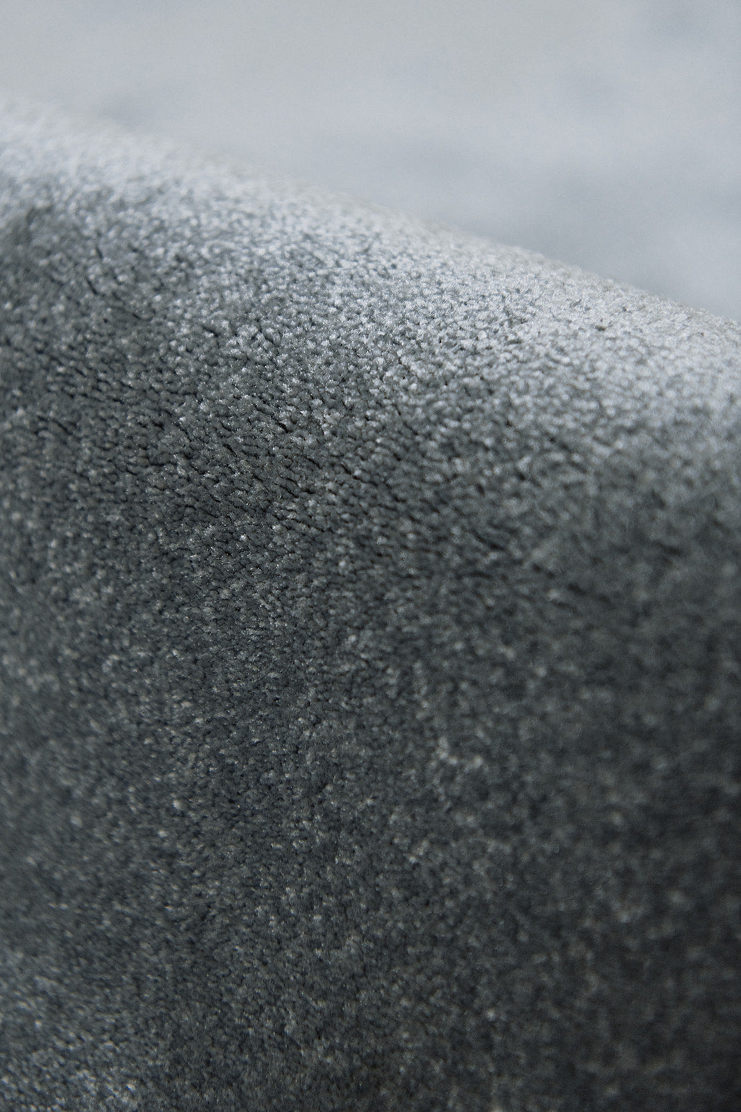 Detail zacht materiaal duurzaam tapijt met opverend garen in een grijze tint, stone kleur.