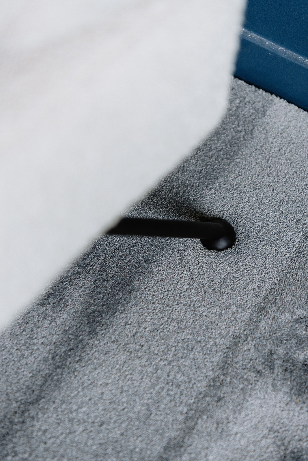 Close-up voet van zetel in zachte textuur en materiaal van duurzaam grijskleurig tapijt.