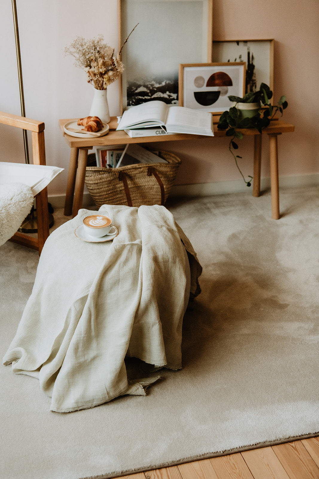 Huiselijk interieur met tijdloos premium kwaliteit tapijt, bijzettafel met interieurobjecten en tafeltje met koffie.