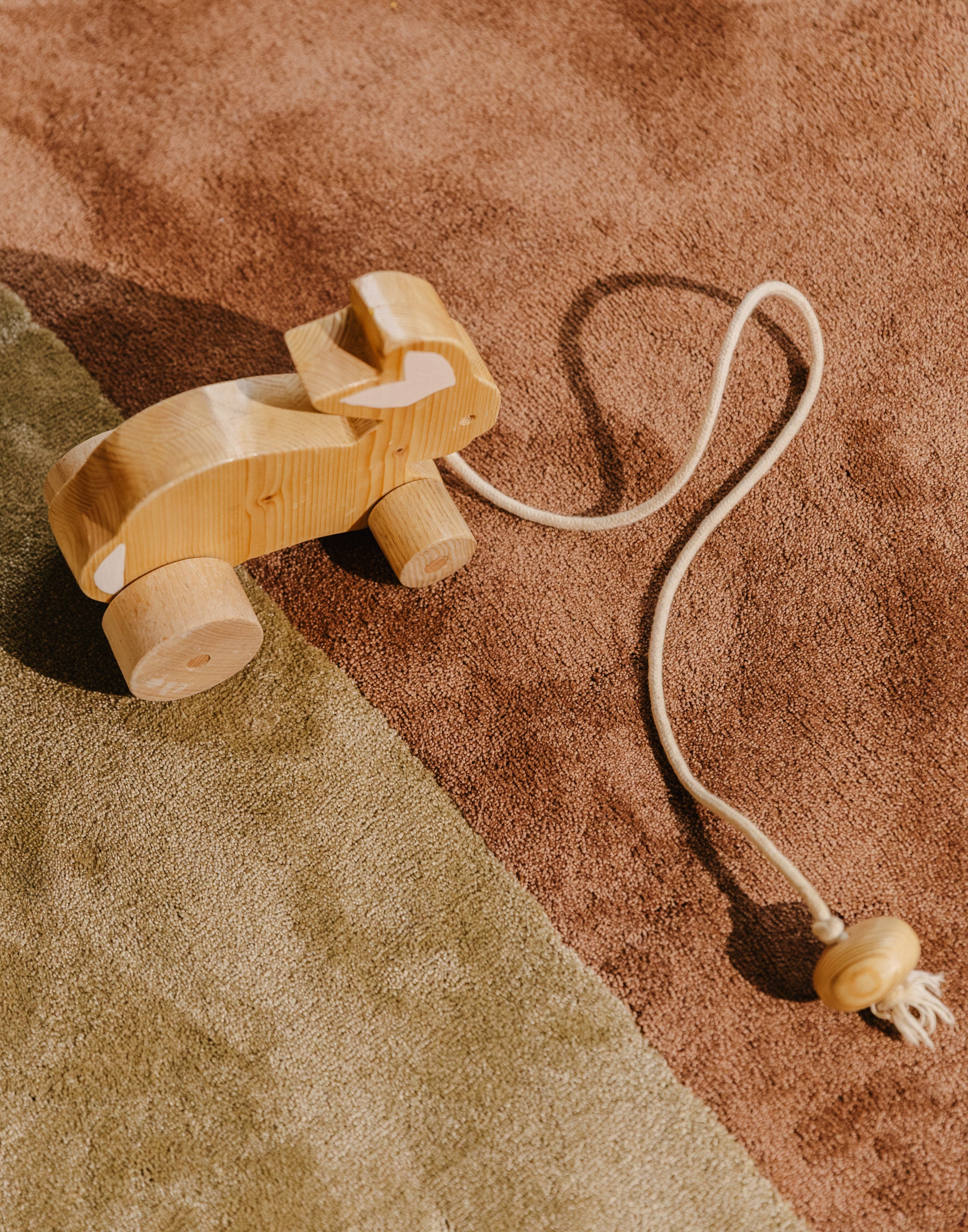 Houten speelgoed op Rhythm modulair tapijt. Olive low & Earth low naadloos aan elkaar verbonden. Future-proof circulair design.