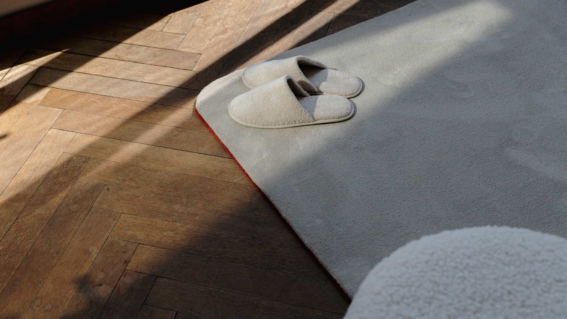 Pantoffels op rechthoekig, zacht duurzaam tapijt en houten parketvloer.