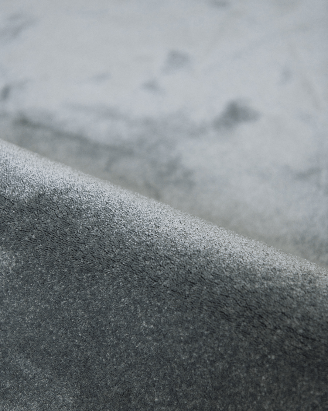 Detail zacht materiaal duurzaam tapijt met opverend garen in een grijze tint, stone kleur.