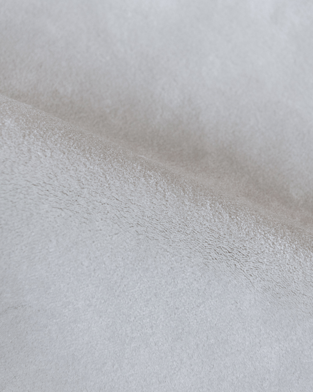 Detail zacht materiaal duurzaam tapijt met opverend garen in een witte tint, tender kleur.