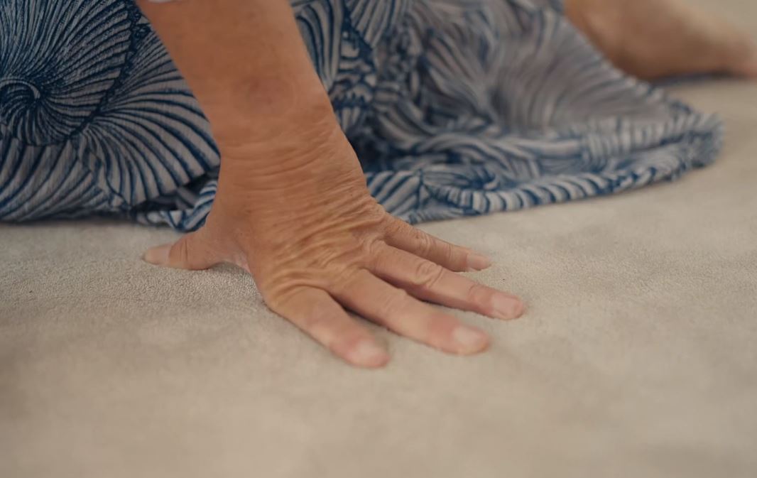Hand op zacht tapijt.